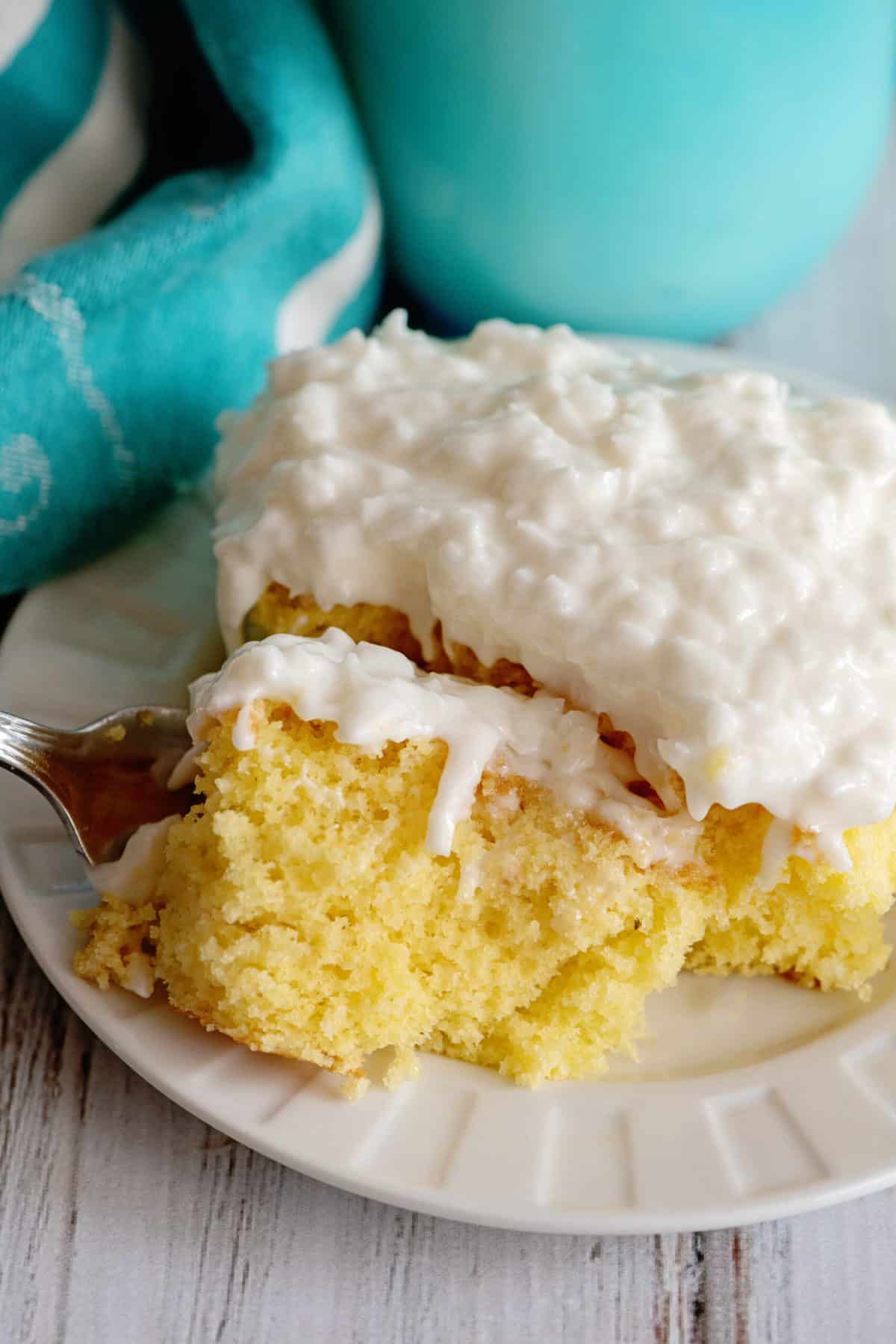 Fork breaking off a piece of coconut poke cake.