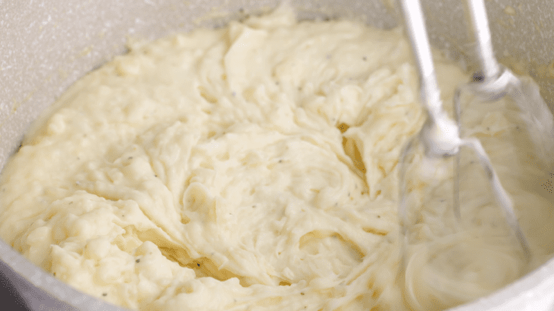 Mash potatoes using a hand mixer.