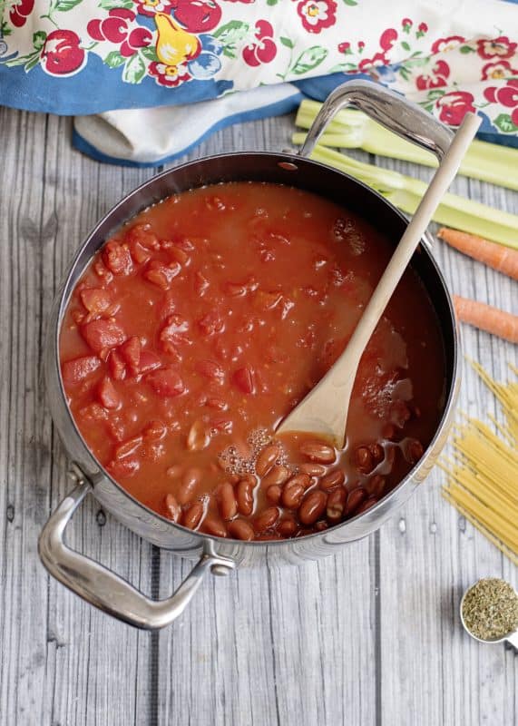 Dump tomatoes, beans, and spaghetti sauce in a large pot.