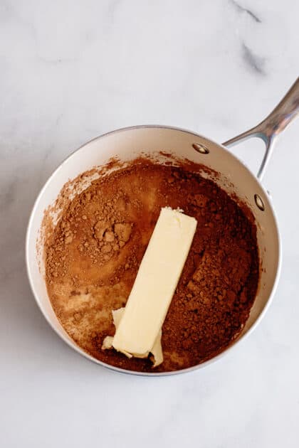 Place butter, cocoa, and milk in a saucepan and bring to a boil.