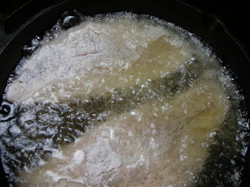 Catfish fillets frying in oil.