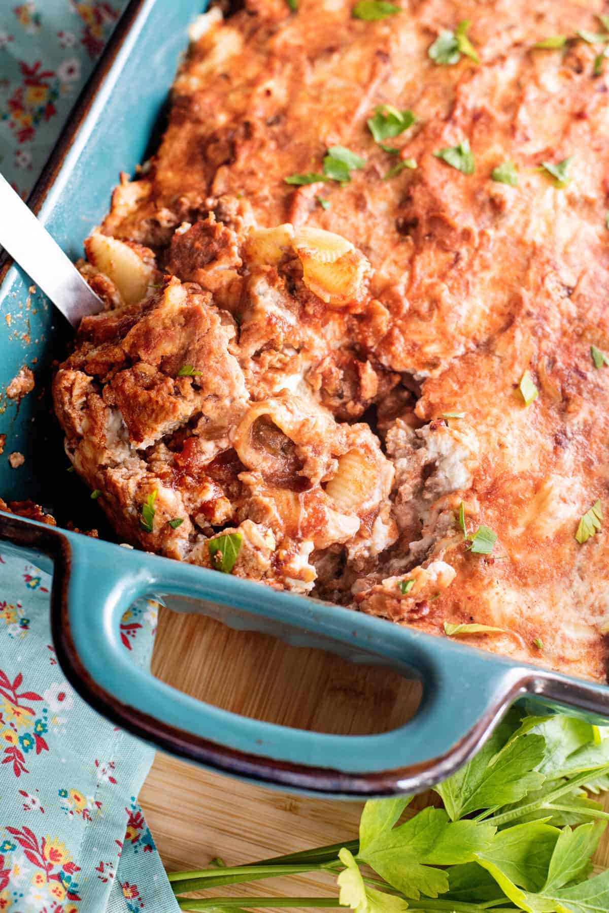 Ladle removing a portion of meatloaf casserole from baking dish.