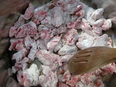 Brown flour-coated beef in a skillet.