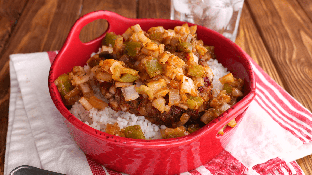 Hamburger patties with gravy on rice.