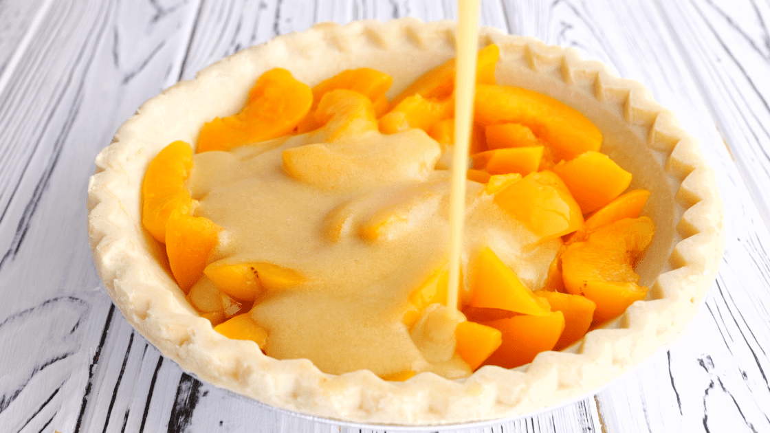 Pour buttermilk pie filling over peaches in pie crust.