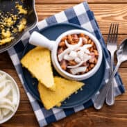 Pinto beans and ham with pickled onions on top and a side of cornbread.