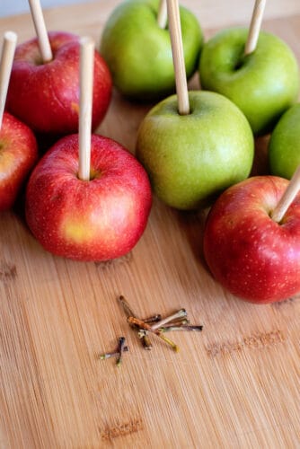 Remove stems to place sticks into apples.