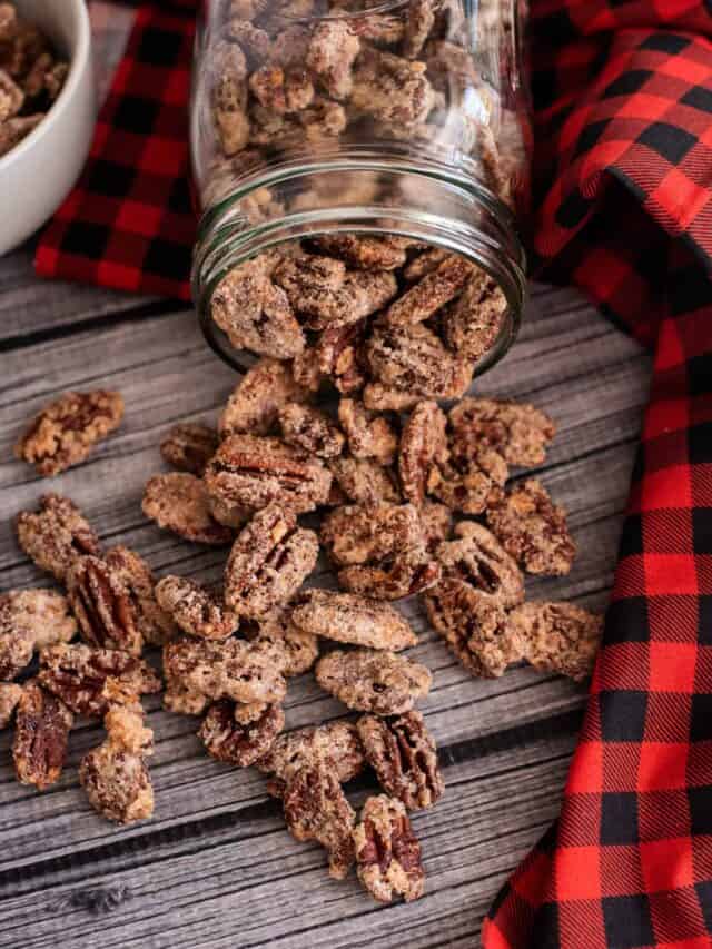 Candied pecans spilling out of a mason jar.