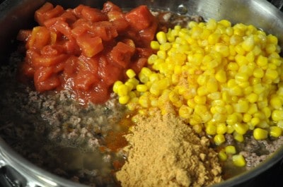 Stir in tomatoes, drained corn, taco seasoning, and water.