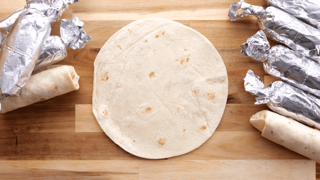 Lay warm tortilla on work surface.