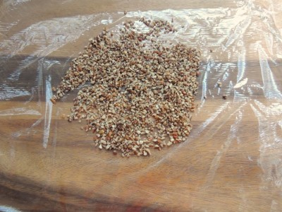 Scatter some finely chopped pecan pieces on top of a piece of plastic wrap.