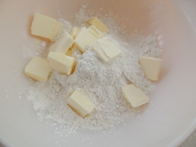 Place flour and butter pats in a mixing bowl.