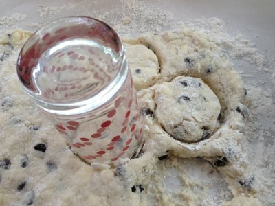 Cut out chocolate chip biscuits with glass.