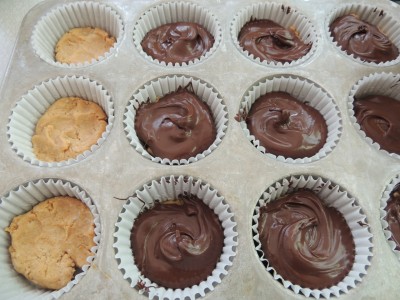 Use spoon to spread chocolate on peanut butter cups.