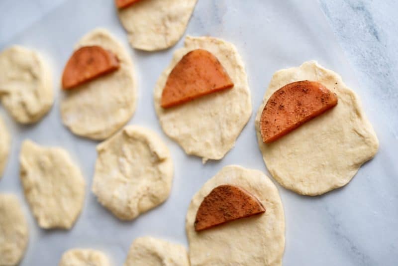 Add sweet potato half to biscuit.