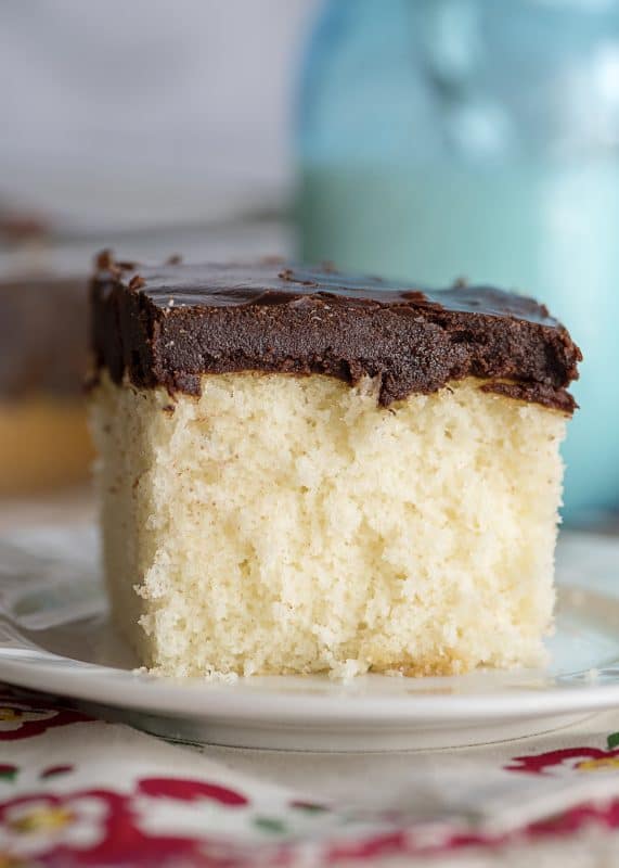 Slice of white cake with boiled chocolate icing.