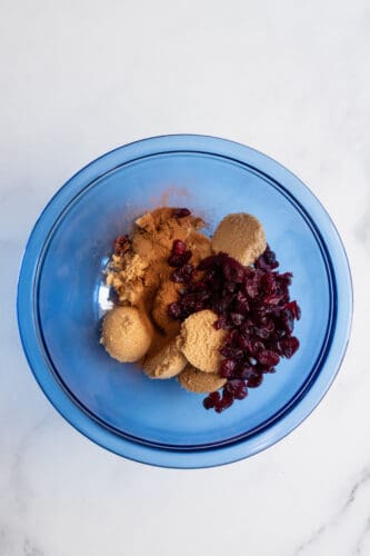 Brown sugar and cranberries on mixing bowl.