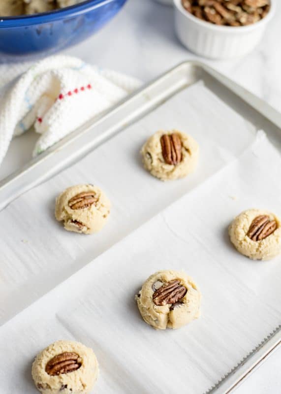 Press a pecan into the top of each cookie and bake.