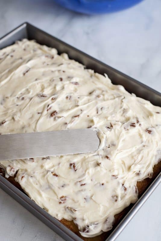 Spread pecan cream cheese icing on top of cake.