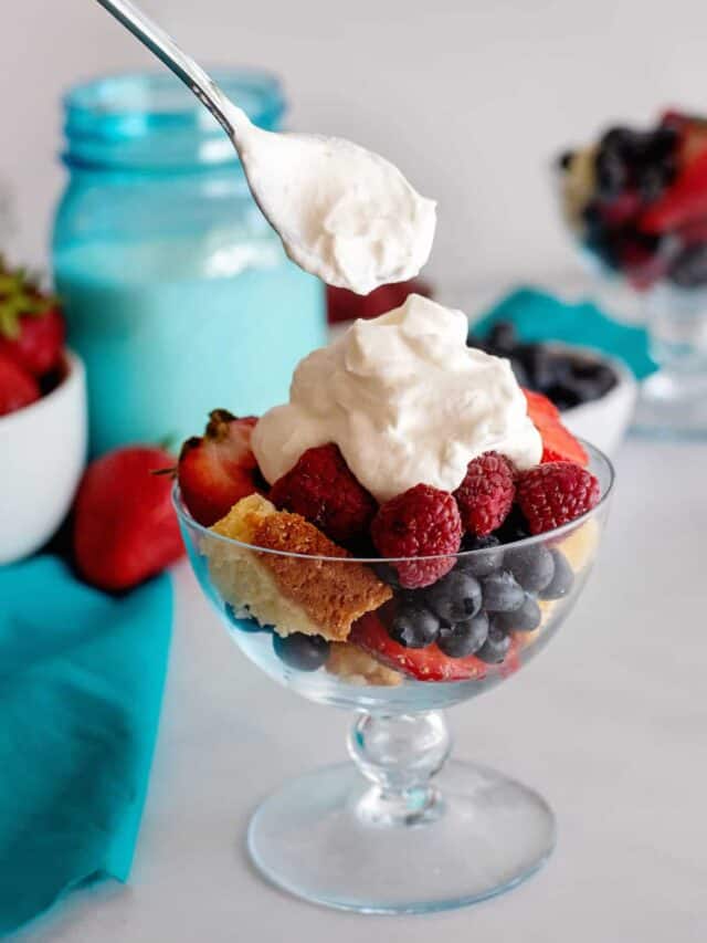 Dollop of homemade whipped cream on fruit salad.