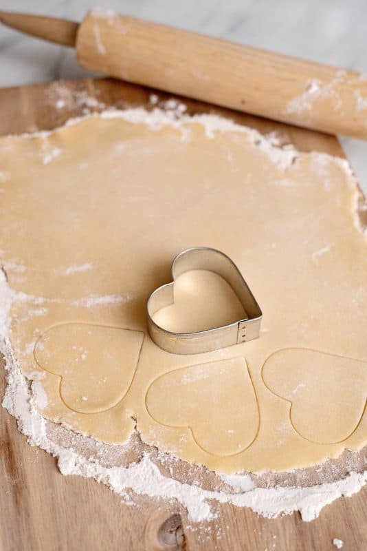 Cut out dough with heart shaped sugar cookie cutter.