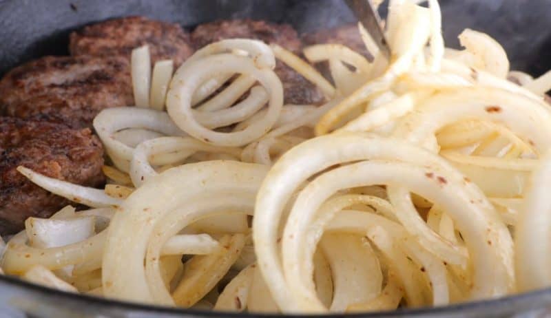 vidalia onions frying in pan with hamburger steak patties