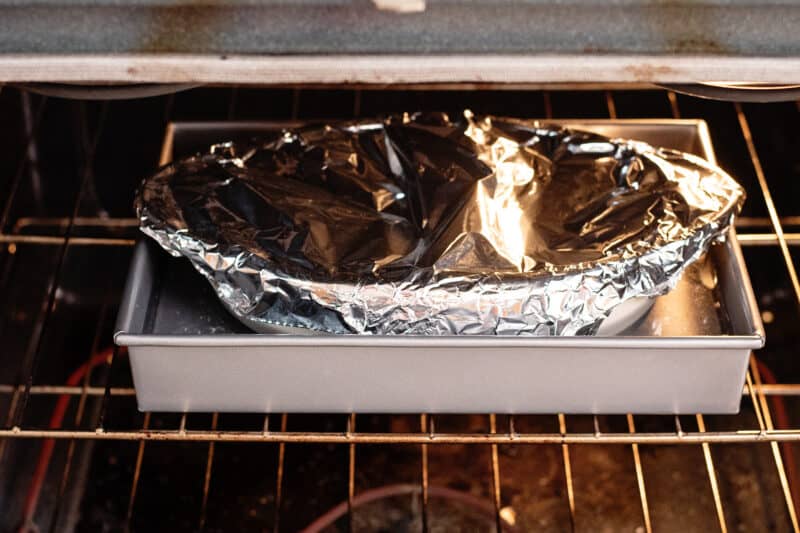 Place pan with pie dish covered in foil on middle rack of oven