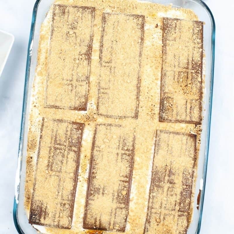 Top with marshmallow cream, chocolate bars, and crumbs.