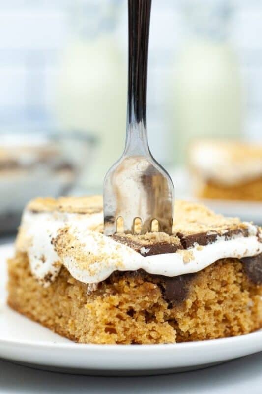 fork stuck into a slice of smores poke cake.