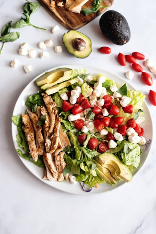 arrange avocado, mozzarella, cherry tomatoes and torn basil