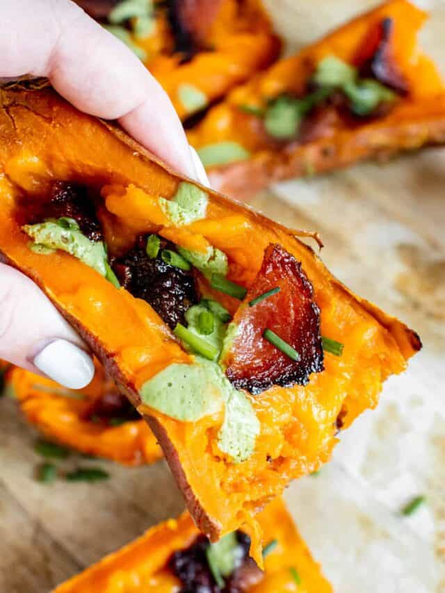 Hand holding a loaded sweet potato skin.