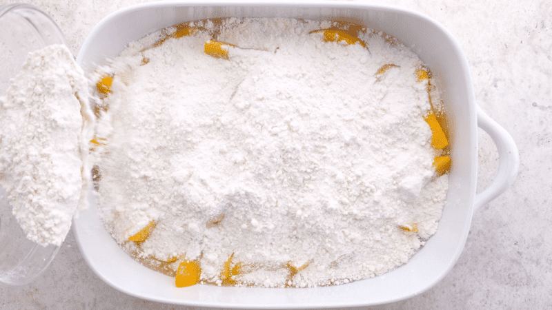 Cake mix sprinkled over peaches.