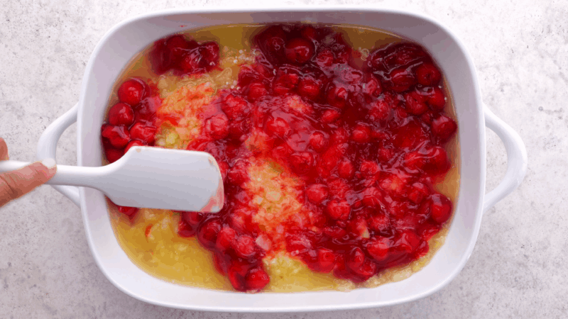 Spread cherry pie filling evenly over pineapple in baking dish.