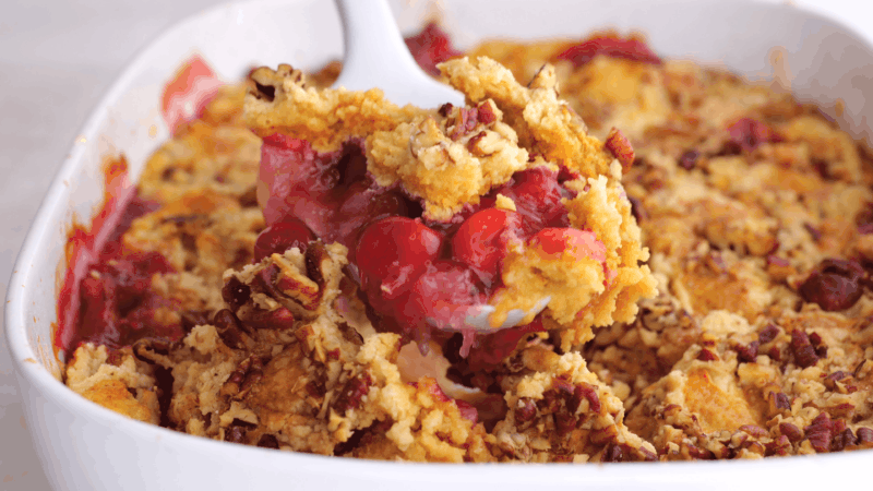 Spatula lifting serve of dump cake out of baking dish.