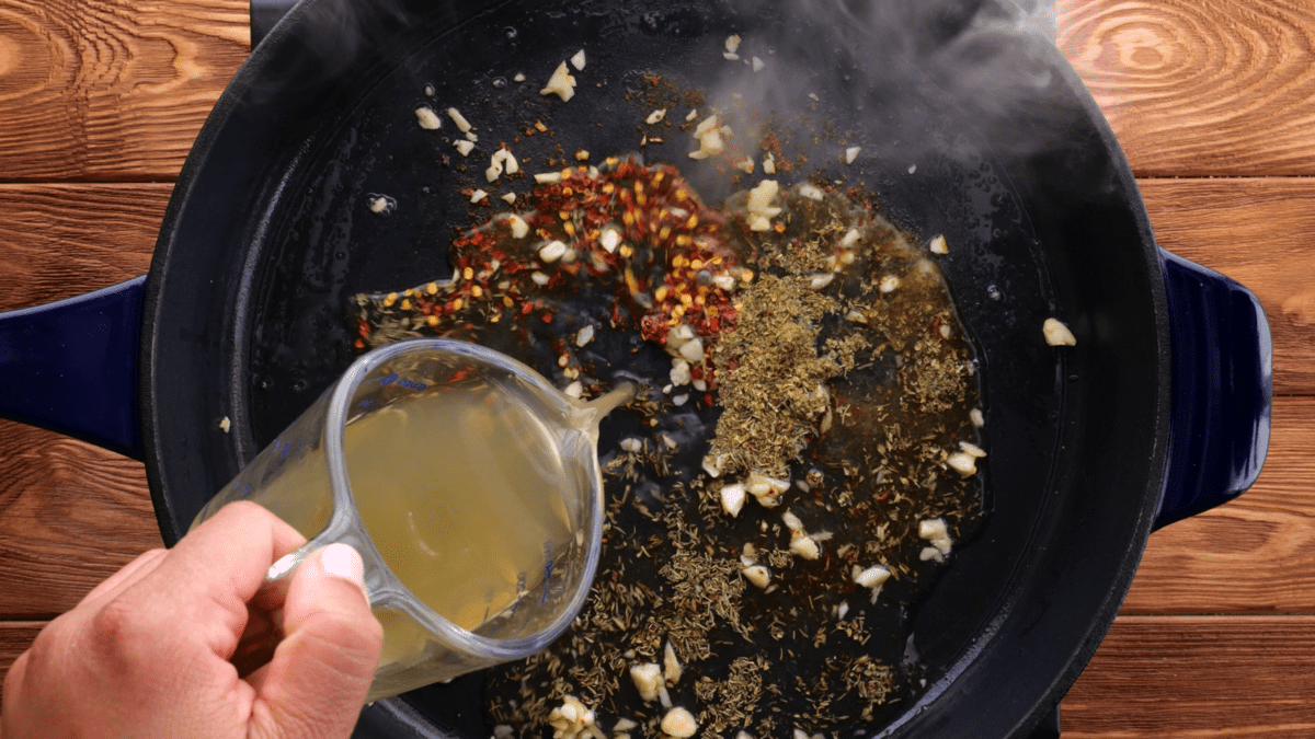 Add chicken broth to skillet.