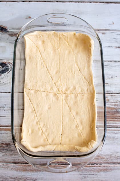 Place crescent roll dough in bottom of greased dish.