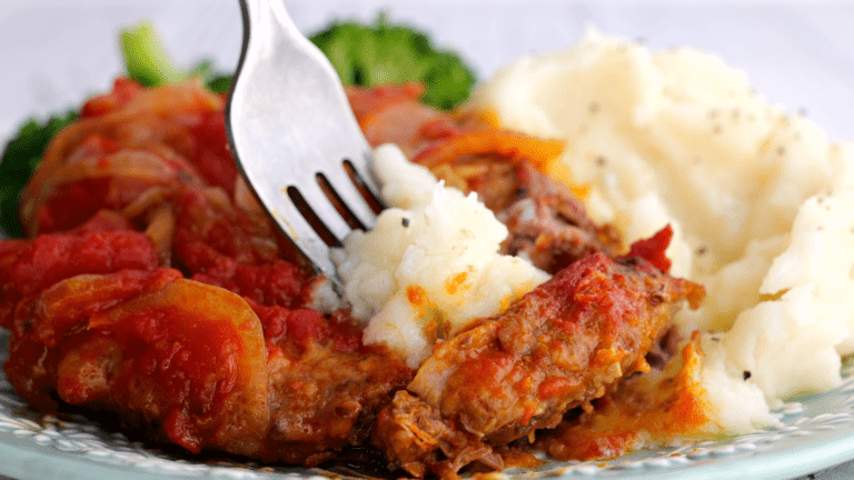 Piece of swiss steak with mashed potato.