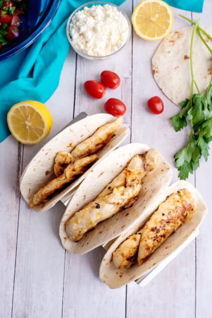 To make Greek chicken tacos, place cooked chicken into flour tortillas.