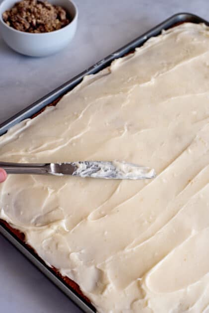 Spread cream cheese frosting evenly over pumpkin bars.