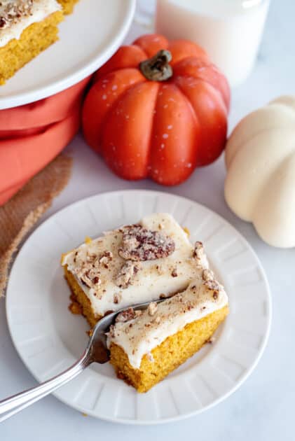 Fork slicing into a pumpkin bar with cream cheese frosting.