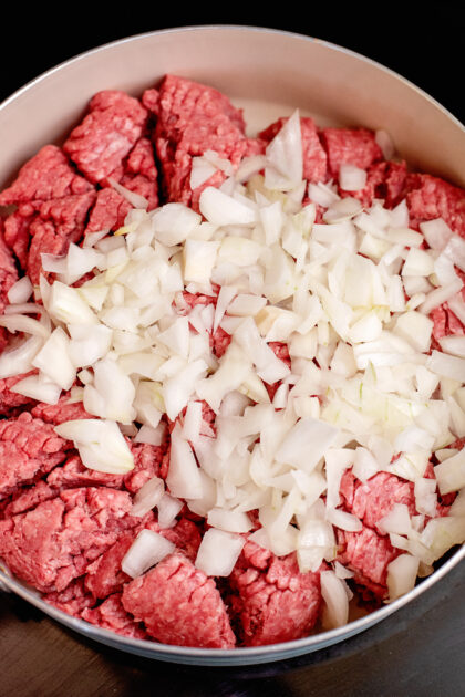 Add chopped onions and beef to skillet.