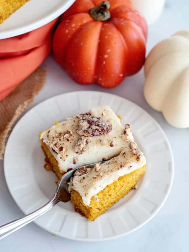 Fork slicing into a pumpkin bar with cream cheese frosting.