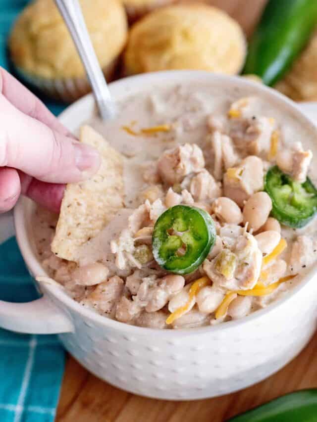 Scooping up white bean chili with tortilla chip.