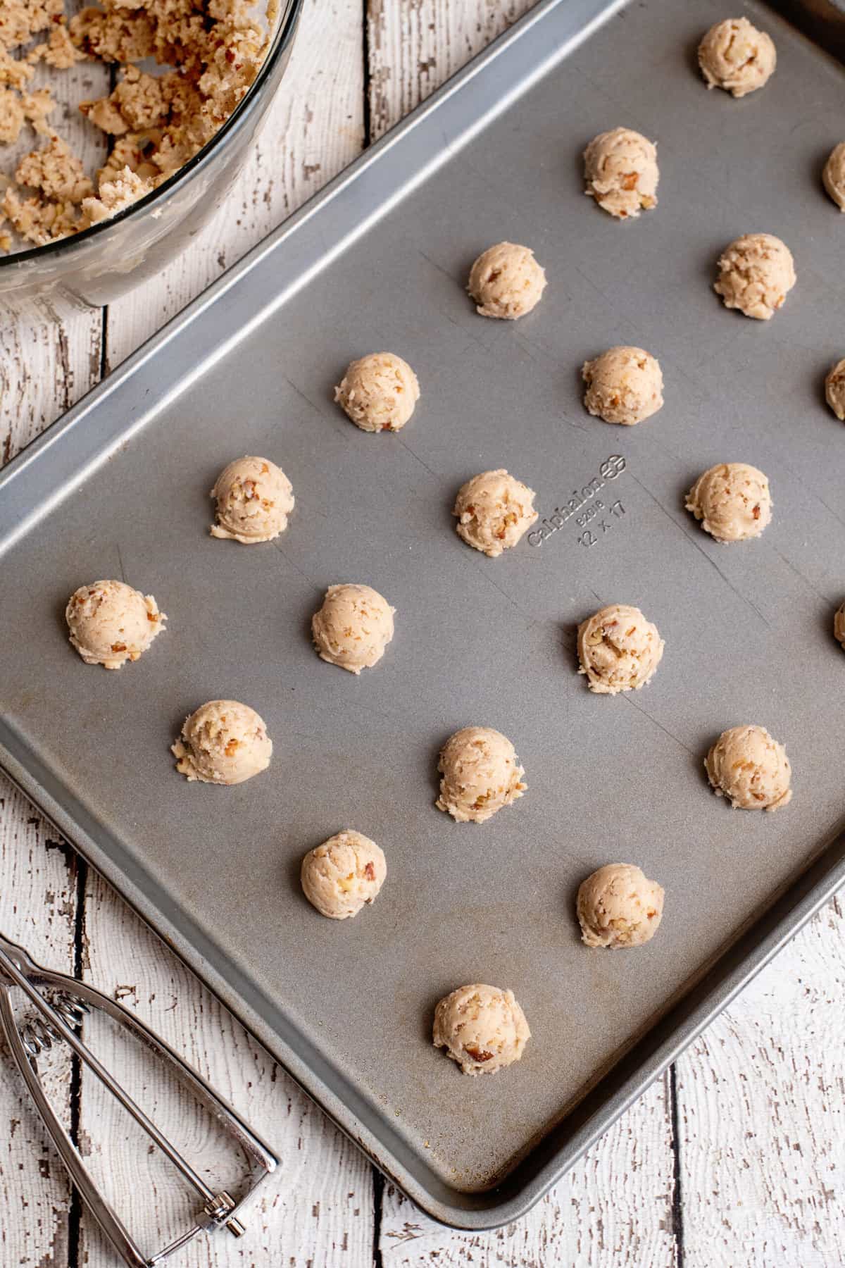 drop pecan thumbprint cookies onto cookie sheet