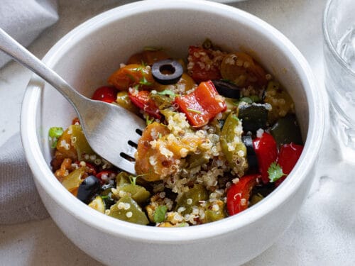 Fork in a bowl of Mediterranean quinoa salad.