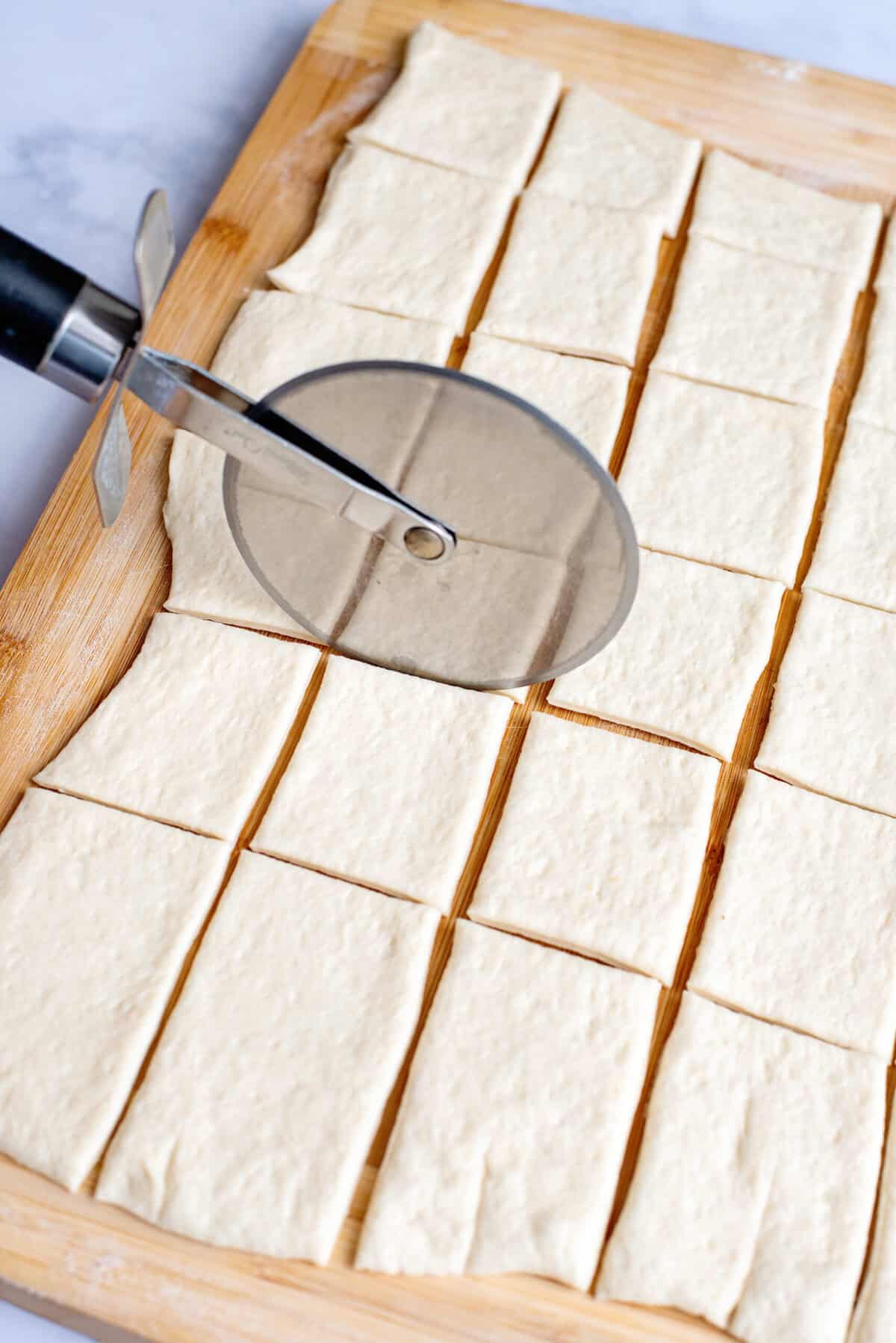 Cut pizza dough into 30 small rectangles