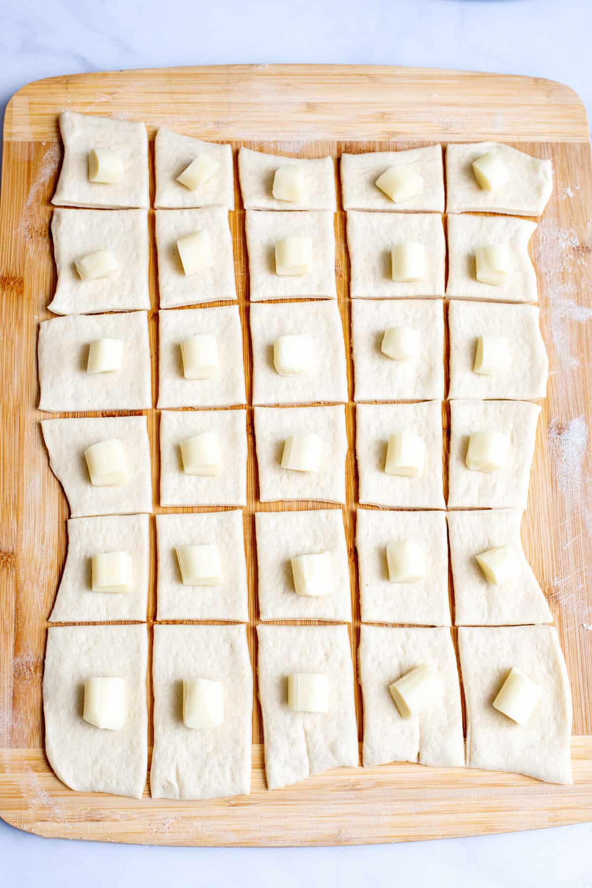 Place cheese on dough squares for the Cheesy Pull Apart Bread Christmas Wreath