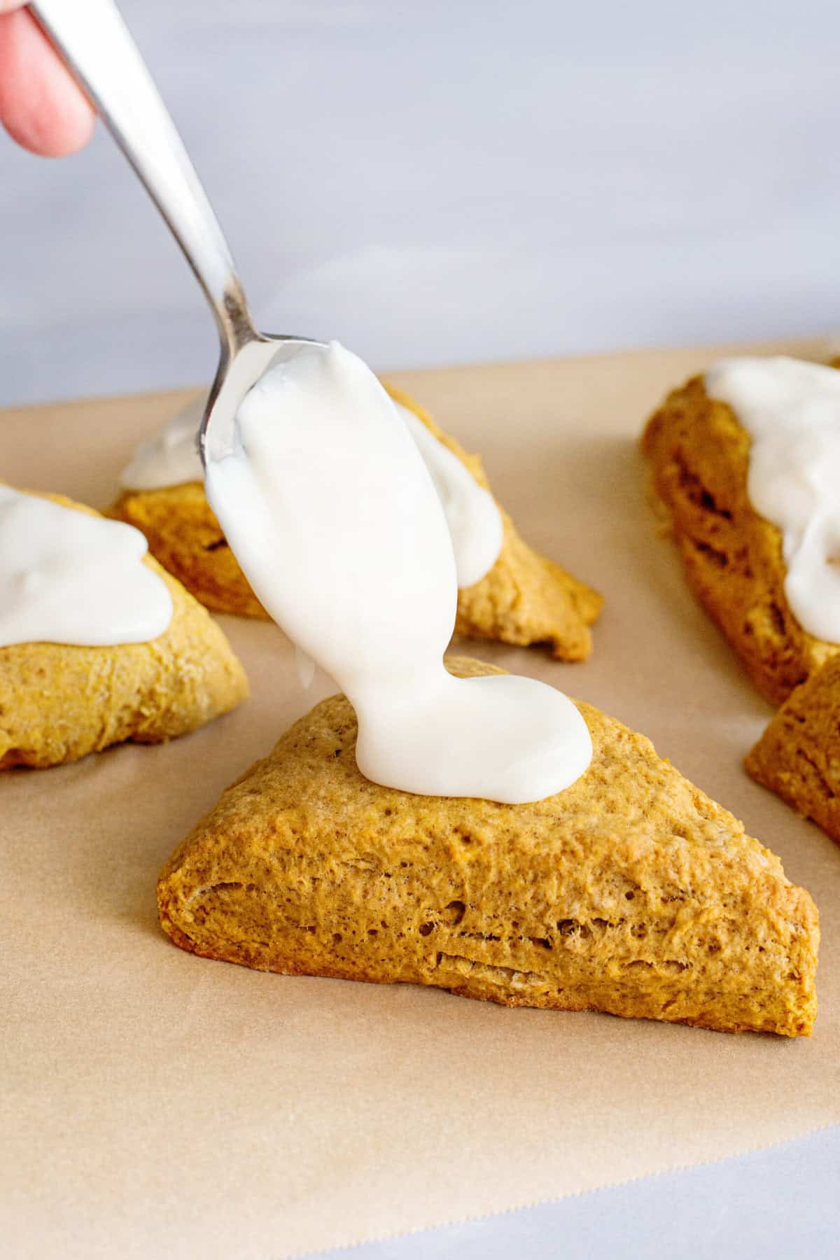 Spoon glaze onto Pumpkin Scones