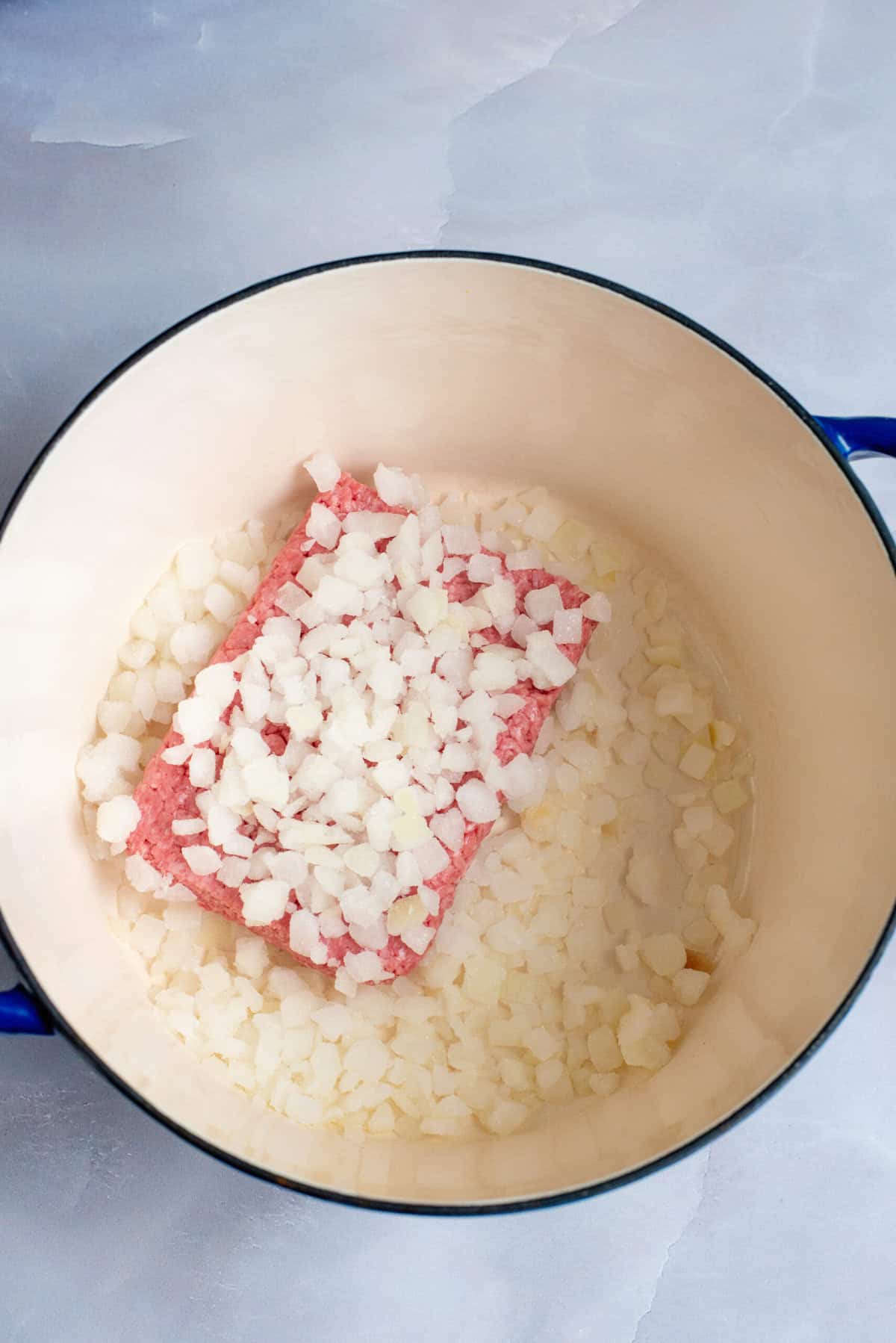 Put ground been and onions in pot