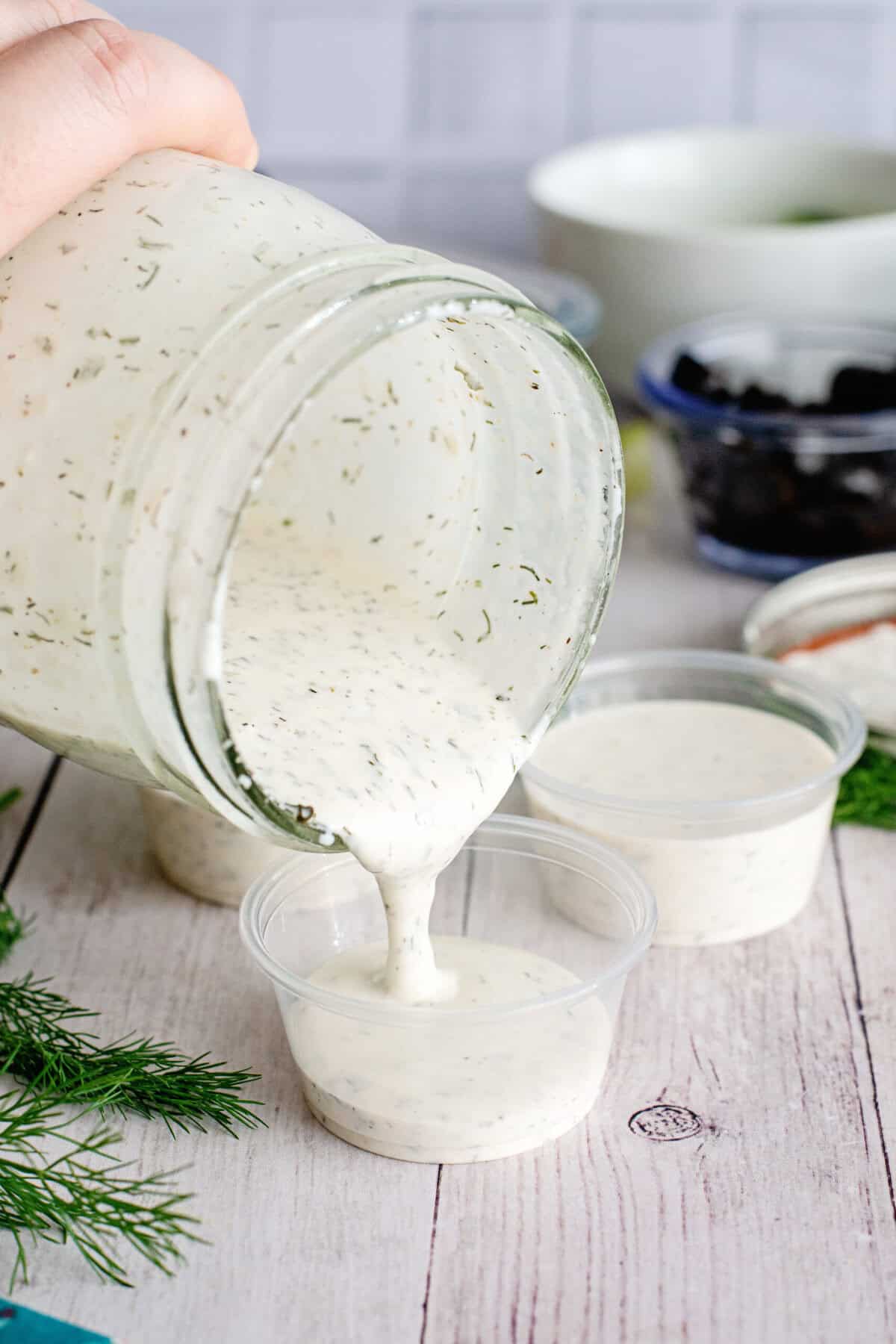 Pour Ranch dressing into individual cups.